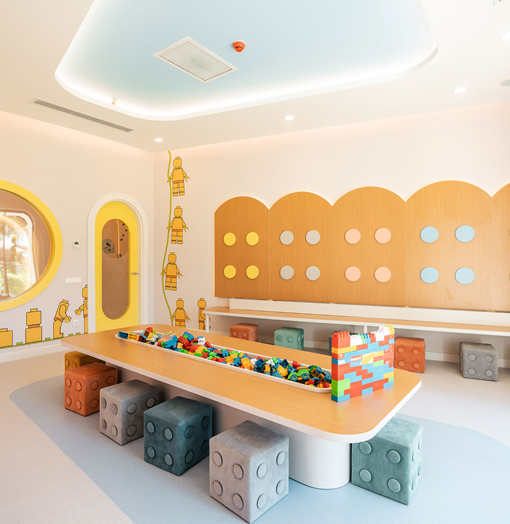 A visual from the children's club of the Kilikya Palace Göynük hotel. In the image, there is a long table where children can sit and there are lego pieces on the table.